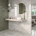 A remodeled bathroom with white tile flooring