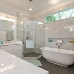 A remodeled bathroom with white countertops