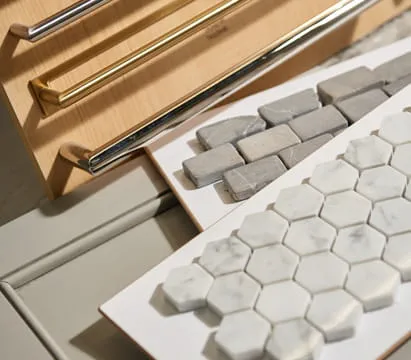 A close-up image of a tile backsplash and cabinet hardware
