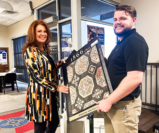 Designer and account manager holding a carpet sample