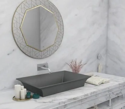Gray bathroom sink shown with circular mirror overhead