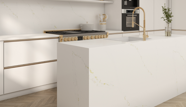 Modern white kitchen island with Daltile Calacatta Alabaster quartz countertops and gold accents.