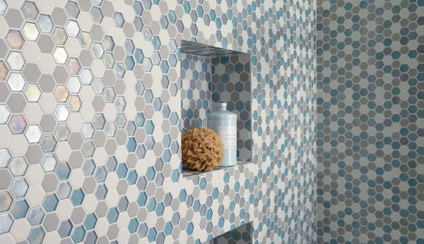Shower wall with blue, gray, and white hexagon mosaic tiles from Daltile Coastal Keystones.