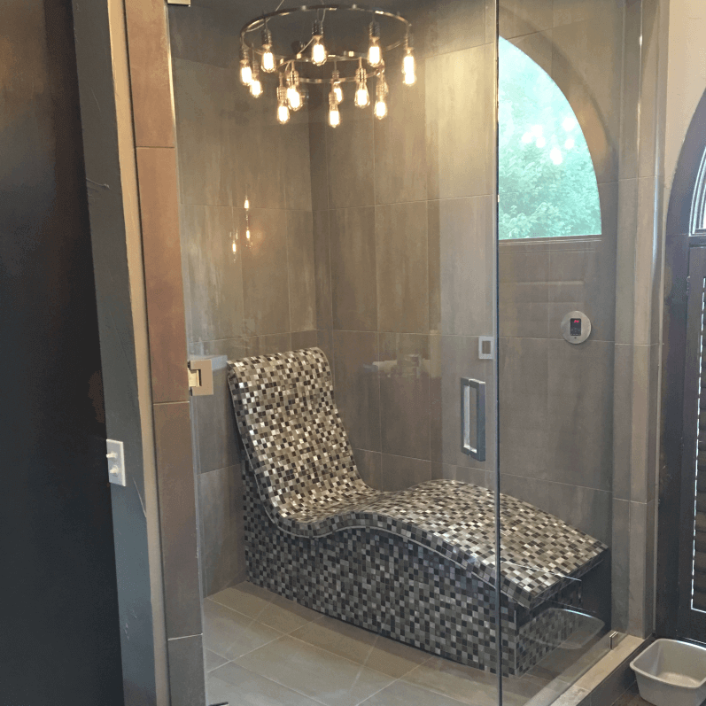 Remodeled bathroom shower with a chandelier and seat