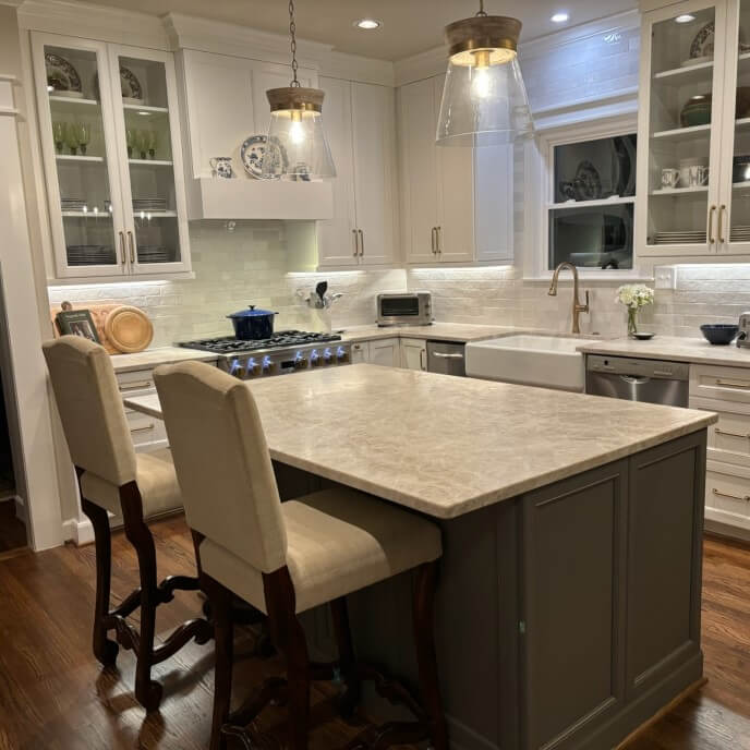 Remodeled kitchen with white cabinets and brown island