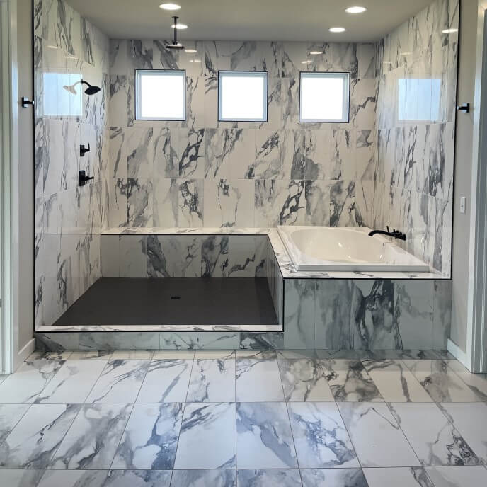 Remodeled bathroom with exquisite gray and white marbled tile in shower