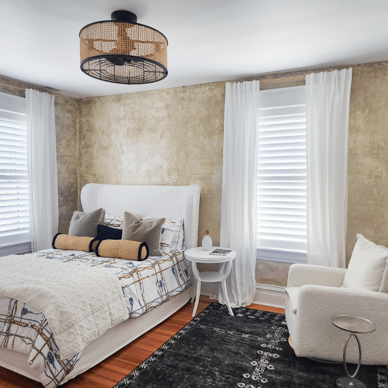 Rich hardwood flooring provides a warm contrast to modern design. A black-and-white patterned rug adds texture, anchoring the sleek furniture in the space.