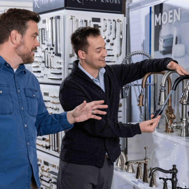 A ProSource account manager showing a member a variety of beautiful Moen faucets.