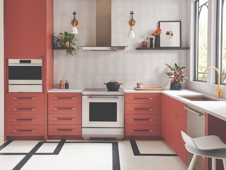 Modern kitchen with bold red cabinetry, white countertops, geometric tile flooring, and sleek brushed nickel Atlas Homewares cabinet pulls.