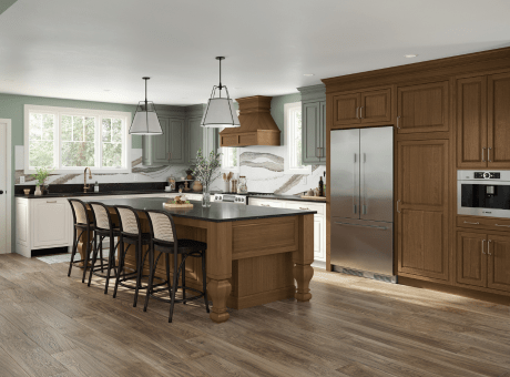 A modern kitchen with wooden cabinets, a central island with stools, and stainless steel appliances.