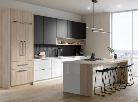 Modern kitchen with wood and white cabinetry, black tile backsplash, island with seating, and hanging light fixtures.