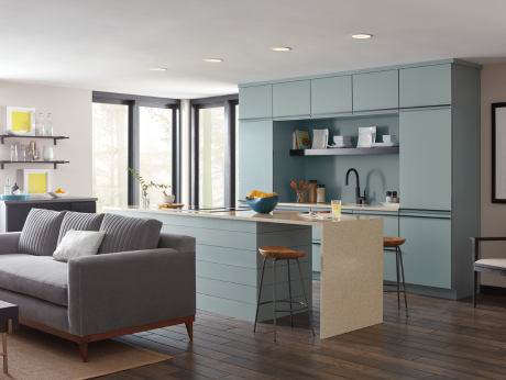 Modern kitchen with teal cabinets, island with waterfall countertop, and wood barstools.