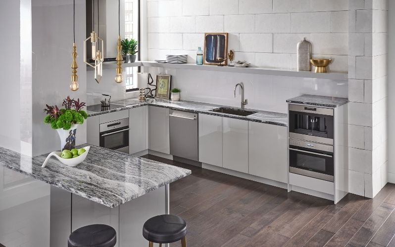 Modern kitchen with granite countertop, cabinetry, appliances, and decor.