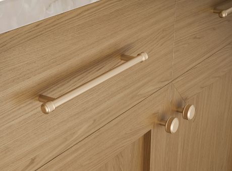 Close-up of a wooden cabinet with metallic knobs and a handle.
