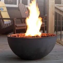 Modern black fire bowl with a bright flame, placed on a wooden deck near Adirondack chairs, creating a cozy outdoor firescape.
