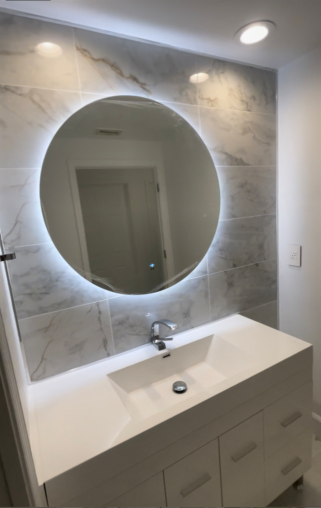 Remodeled bathroom sink and lighted mirror