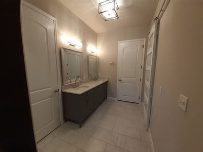 Remodeled bathroom with dark wood vanity, white countertops, and white floors