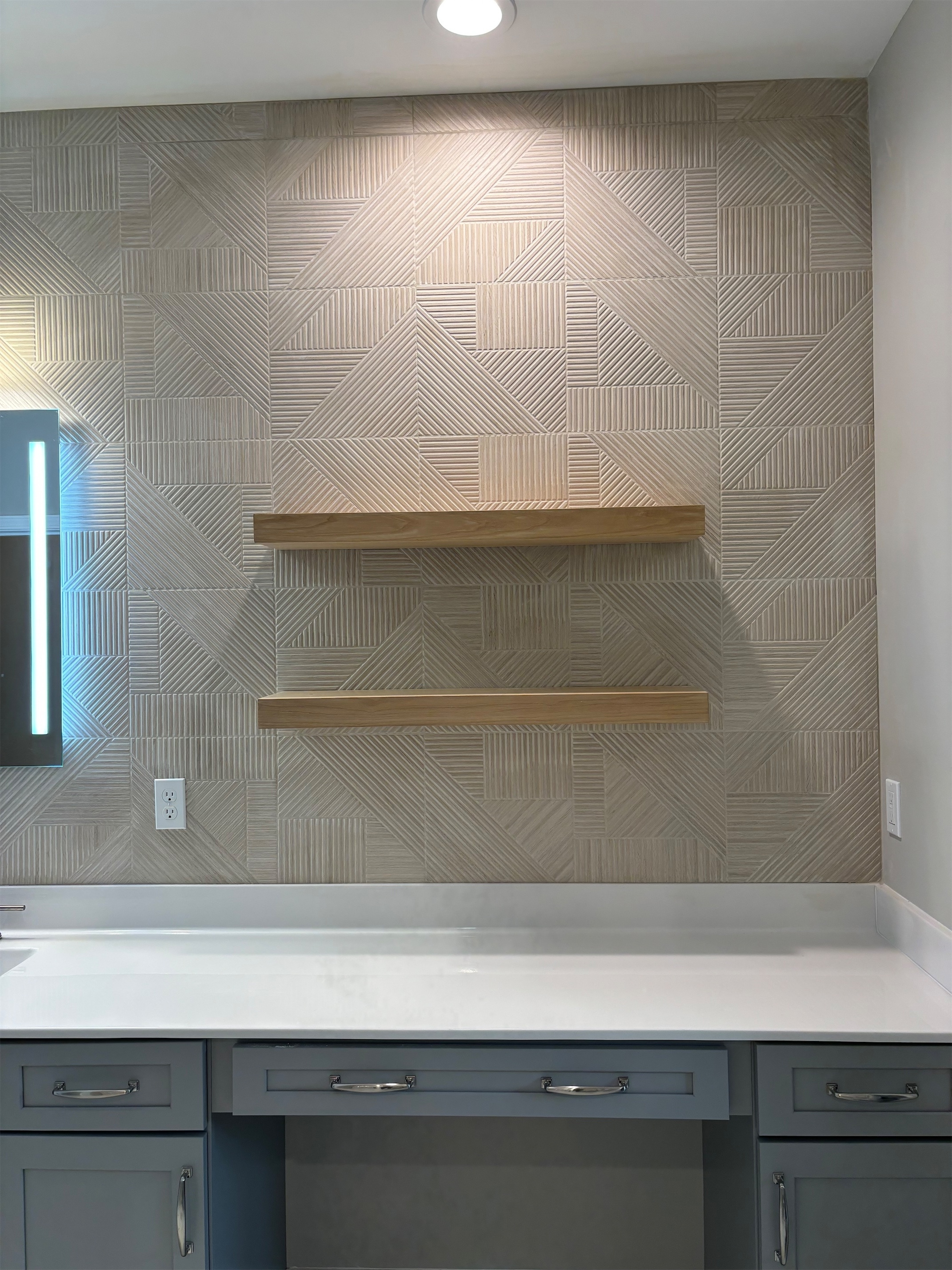 Remodeled bathroom tile backsplash above a vanity