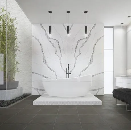 Modern bathroom with freestanding bathtub, Calacatta Wisteria marble wall, pendant lights, and decorative plants.