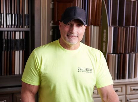 Person wearing a bright-yellow branded shirt standing in front of a product display in a showroom.