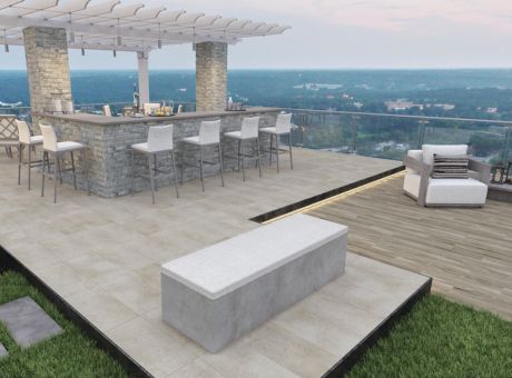Roof terrace with bar counter, high chairs, a seating area, and scenic background.