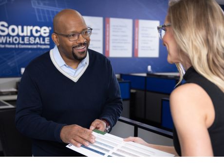 Two individuals in a business setting engaging in a conversation near a counter.
