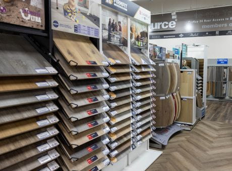 Assortment of flooring samples displayed in racks at a store, featuring various styles and materials.