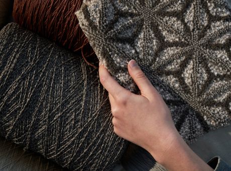 Anderson Tuftex carpet samples in various colors and textures with a hand touching one sample.