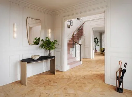 Home entryway with high-quality hardwood flooring, a console table adorned with plants, and a staircase in the background.