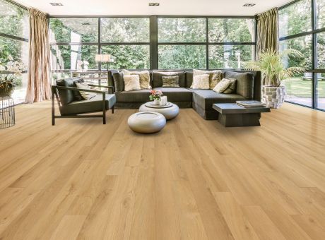 A modern living room with a glass wall, contemporary furniture, and wooden flooring.