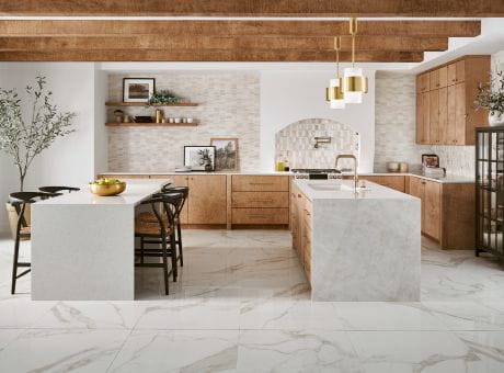 Modern kitchen with wooden cabinets and marble countertops, featuring pendant lights and minimal decor.
