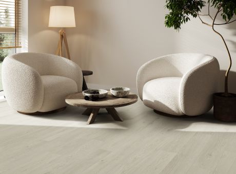 Living room with Engineered Floors vinyl flooring, two round chairs, a wooden coffee table, a floor lamp, and a potted plant.