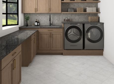 Image of a modern laundry room with wooden cabinets, black countertops, washing machine, dryer, shelves, and a window.