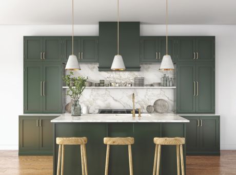 Modern kitchen with dark green cabinets, pendant lighting, and marble backsplash.