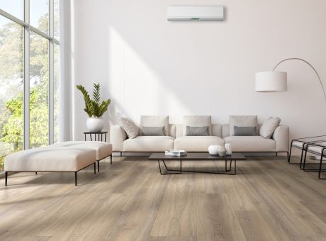 Modern living room with beige furniture, large windows, and an air conditioning unit on the wall.