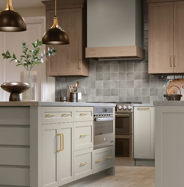 Modern kitchen setup showing light cabinets with gold handles, a tiled backsplash, and pendant lights.