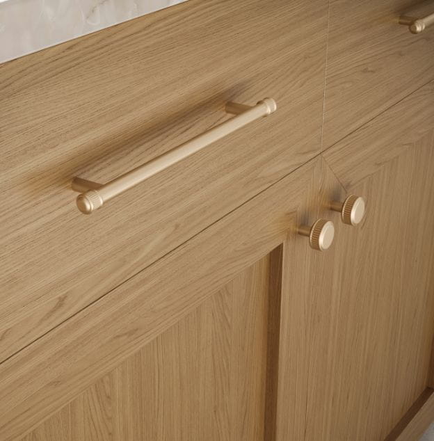 Close-up of cabinet hardware including a long handle and round knobs on a wooden cabinet.