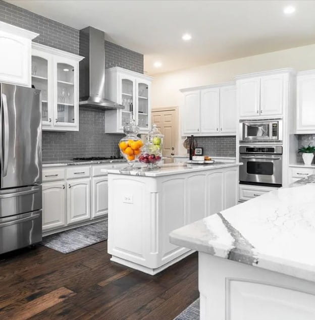 A remodeled kitchen with white cabinets