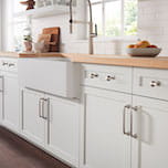 A close-up of cabinet hardware with a silver finish