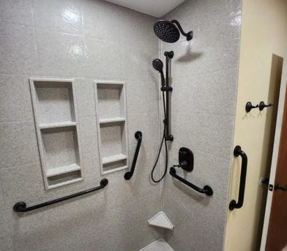 Bathroom shower area with safety rails and modern shower fixtures designed for accessibility.