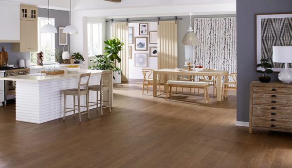 An open-concept kitchen and dining area featuring Mohawk TecWood engineered hardwood.