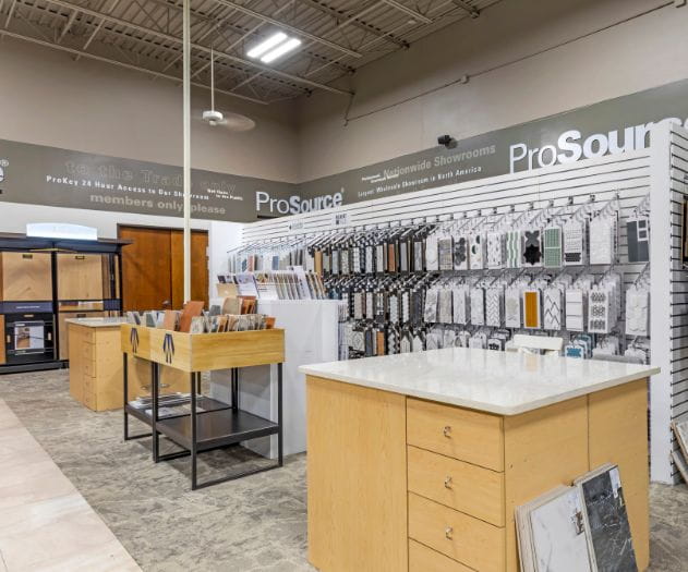 A showroom area with tiling samples and countertop materials displayed on racks and tables.