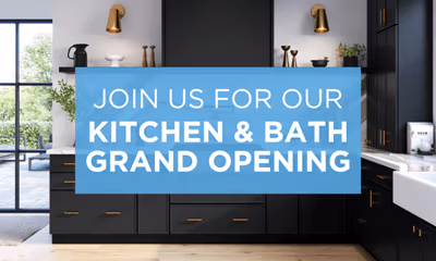 A promotional image for the grand opening of a kitchen and bath store, showcasing a modern kitchen design with a large banner reading 'Join Us For Our Kitchen & Bath Grand Opening'.