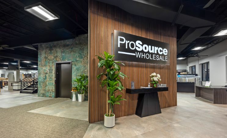 Interior view of a modern wholesale store entrance with a sign reading 'ProSource Wholesale', plants, and elegant decor.