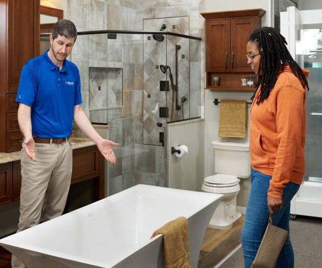 Account manager and homeowner looking at a bathtub
