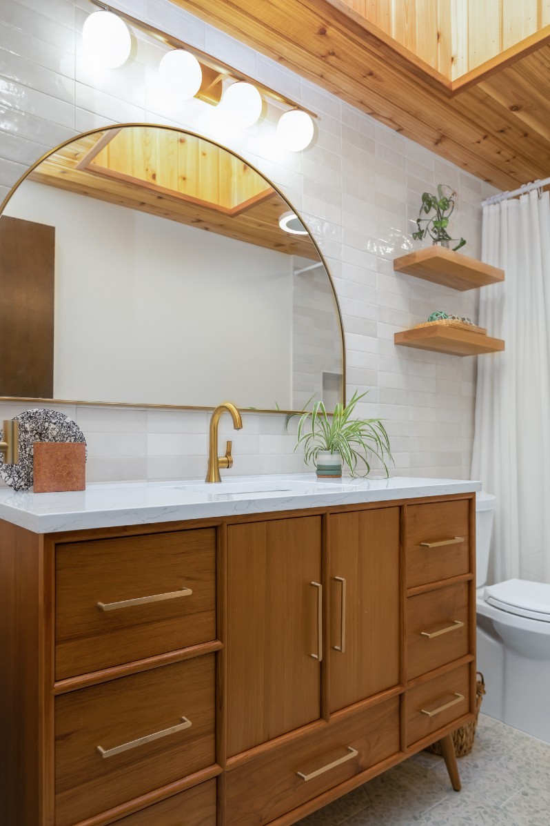 Wood cabinets with gold sink hardware in bathroom scene