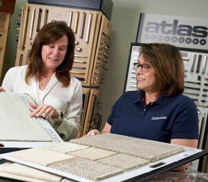 Account manager and interior designer meeting with an Atlas Cabinet Hardware sign overhead